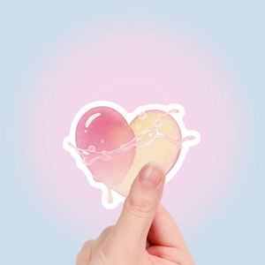Detail of artistic watercolor heart sticker held by hand showing size and texture