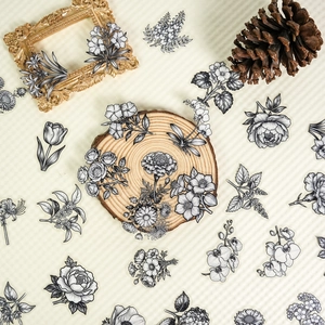 Detailed view of 56 vintage black and white floral PET stickers on a decorative background