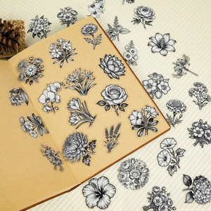 Macro view of vintage black and white floral PET stickers on a notebook page