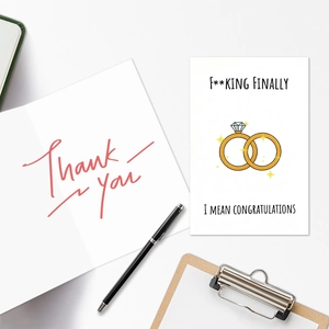 Flache Ansicht der Hochzeitskarte mit Goldringen, lustigem Text und rotem Dankesschriftzug