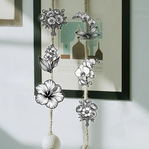 Detail of minimalist black and white floral PET stickers hanging on a decorative twine rope
