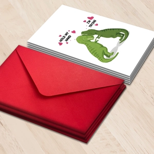 Grappige dinosaurus Valentijnskaarten set met rode enveloppen op licht houten blad