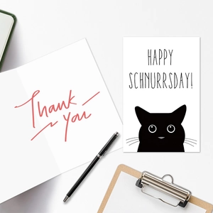 Close-up of cat birthday card set with Happy Schnurrsday text on white background