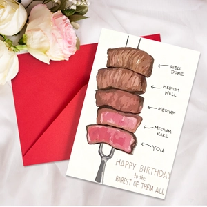 Humorous birthday card with hand-drawn steak illustrations and a vibrant red envelope
