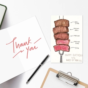 Detailed view of humorous steak-themed birthday and red text thank you card stationery set
