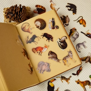 Realistic forest animal PET stickers applied on vintage book pages for DIY journaling