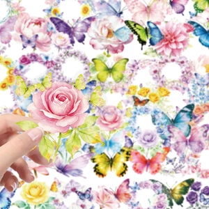 Primo piano di una mano che tiene un adesivo con farfalla e rosa per decorazioni DIY
