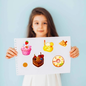 Detail of colorful cartoon dessert stickers being held by a child for creative DIY play