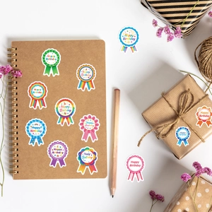 Colorful Happy Birthday badge stickers on kraft notebook and gift box with dried flowers