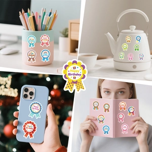 Close-up showing colorful Happy Birthday medal stickers on laptop and water bottle