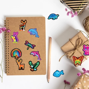 Neon animal stickers shown on a kraft notebook and gift box in a creative setup