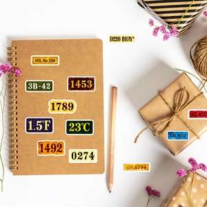 Vue macro d'autocollants numérotés vintage sur carnet kraft avec accessoires