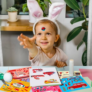 Detail of a child playing with rescue vehicle themed DIY puzzle stickers in a bright room
