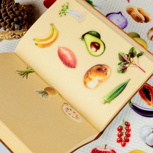 Close-up of realistic fruit and vegetable PET stickers on vintage book pages