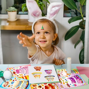 Fillette souriante jouant avec des autocollants de gâteau d'anniversaire DIY et loisirs