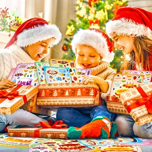 Enfants ouvrant une boîte cadeau avec autocollants de gâteau près du sapin de Noël