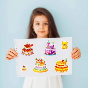Détail d'autocollants de gâteaux colorés avec texte Happy Birthday tenus par un enfant