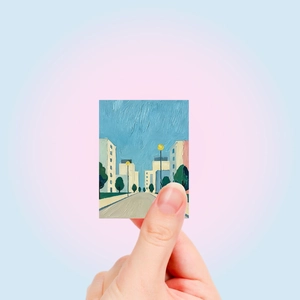 Handheld oil painting sticker showing a scenic city street with blue sky and architecture