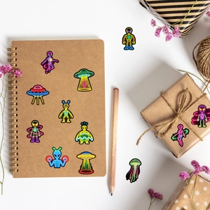 Adesivi graffiti neon alieni e UFO decorati su un taccuino in carta kraft marrone e regalo