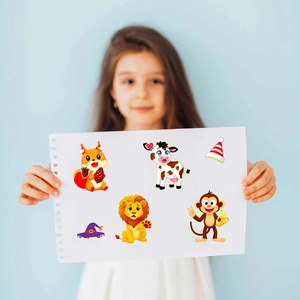 Detail of a child holding cartoon animal face swap stickers with cute lion and cow designs