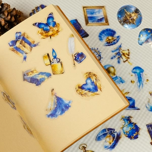 Close-up of Klein blue and gold vintage PET stickers on a scrapbooking journal page