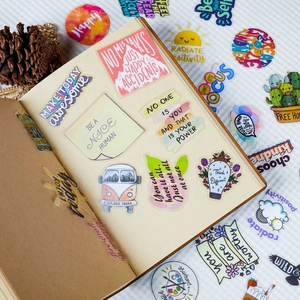 Close-up of waterproof PET stickers with motivational quotes on a vintage journal page