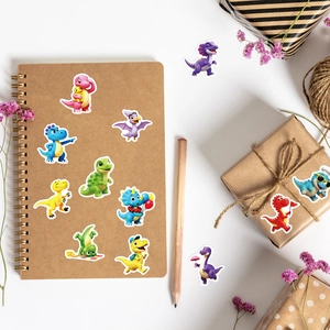 Detail of cute 3D cartoon dinosaur stickers scattered on a kraft notebook and gift box