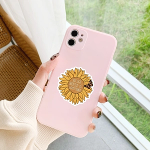 Close-up of pink phone case with sunflower pattern and inspirational text