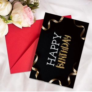 Close-up of Happy Birthday neon card and red envelope on elegant white silk background