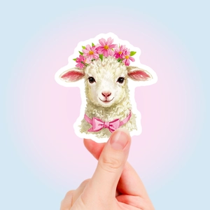 Close-up of a die-cut white sheep sticker with pink flowers and a bow for scrapbooking
