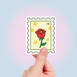 Détail d'un autocollant style timbre avec motif rose rouge et bords festonnés décoratifs