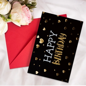 Detail of neon Happy Birthday card with gold heart and vibrant red envelope on silk