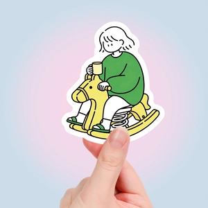 Detail showing a cartoon sticker of a person on a yellow rocking horse for planners