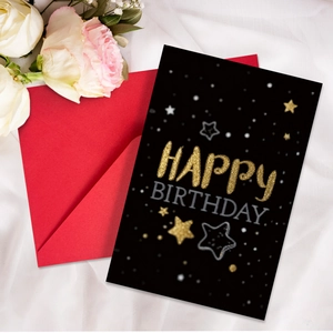 Macro shot of neon Happy Birthday card with stars and a premium red envelope on silk