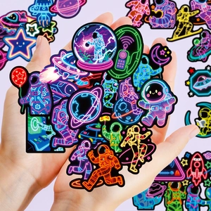 Neon space astronaut graffiti stickers held in hands for laptop and luggage decor