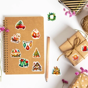 Flat lay of vintage Christmas stickers with Santa and reindeer on a kraft paper notebook