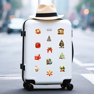 Close-up of assorted festive Christmas stickers applied to a white suitcase surface