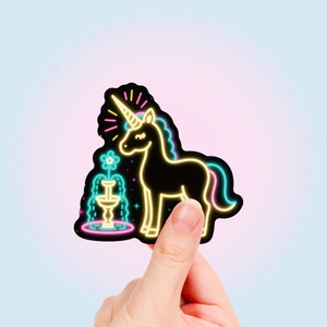 Neon unicorn graffiti sticker held by hand featuring vibrant glowing colors on black base
