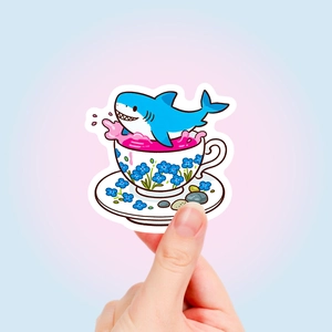 Close-up of waterproof shark tea cup sticker held by hand with cute cartoon details