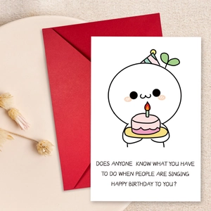 Creative birthday card set with cute cartoon figure and red envelope on a ceramic plate