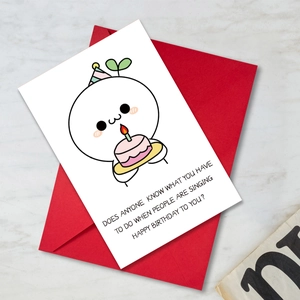 Detail of funny birthday card with cute cartoon character and a bright red envelope