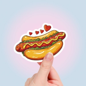 Close-up of waterproof cartoon hot dog sticker with hearts held by hand on pastel background