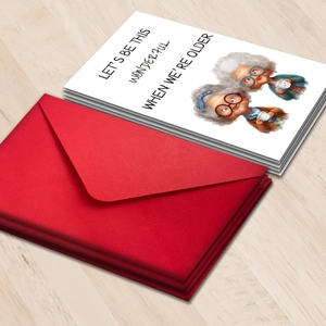 Detailopname van grappige wenskaarten voor ouderen met rode enveloppen op hout