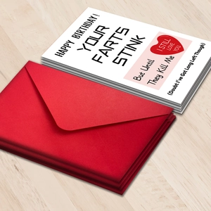 Detailed view of humor birthday cards set with red envelopes on wood background