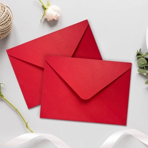 Detailed view of premium red gift envelopes arranged with rustic twine and dried flowers