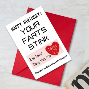 Macro view of funny birthday card with humorous quote and a vibrant red envelope