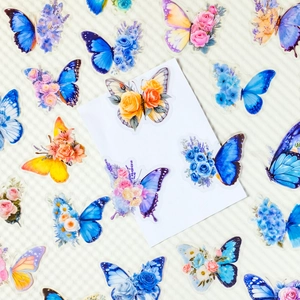 Detailed close-up of floral and butterfly PET stickers on textured beige background