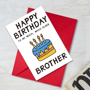 Folded birthday card with funny cake illustration and a red envelope on marble background