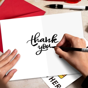 Close-up of minimalist thank you card with red envelope and handwriting scene