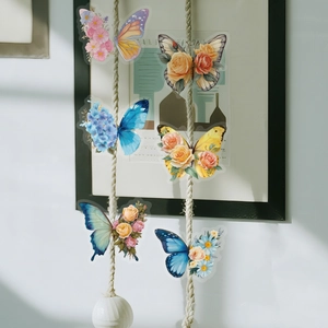 Close-up of decorative PET butterfly stickers with floral patterns on a white wall